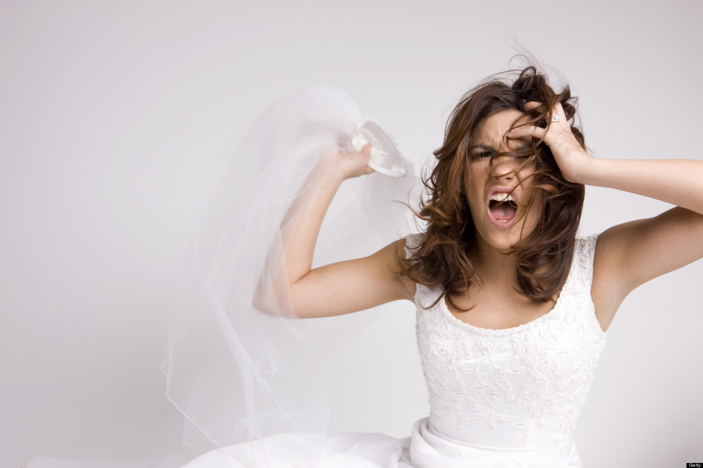 Angry Screaming Bride Throwing Veil on White, Copy Space