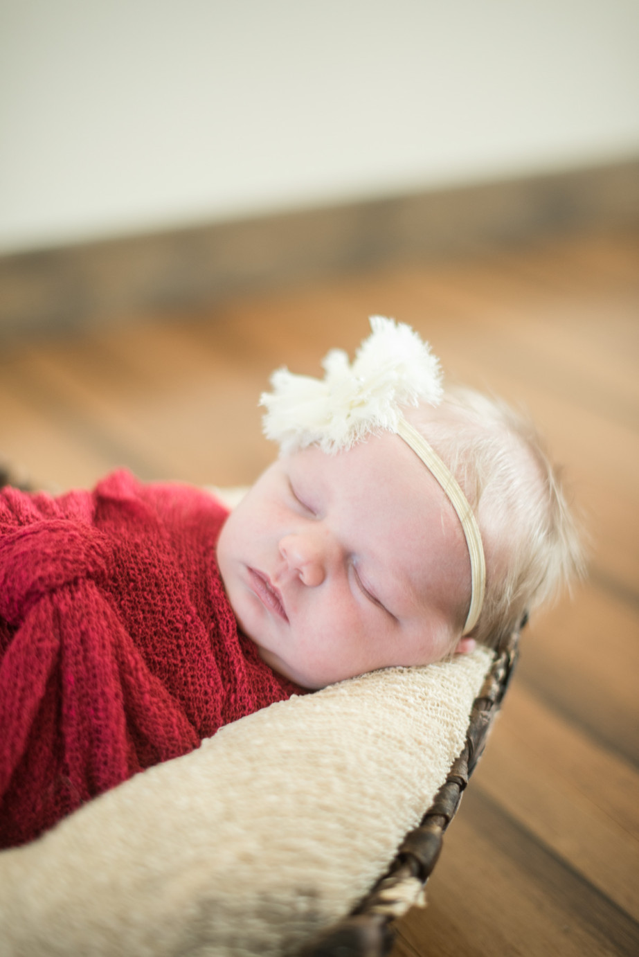 Newborn Photographer Trios Hosptial Kennewick WA Baby girl with beige headband on wood floor photo