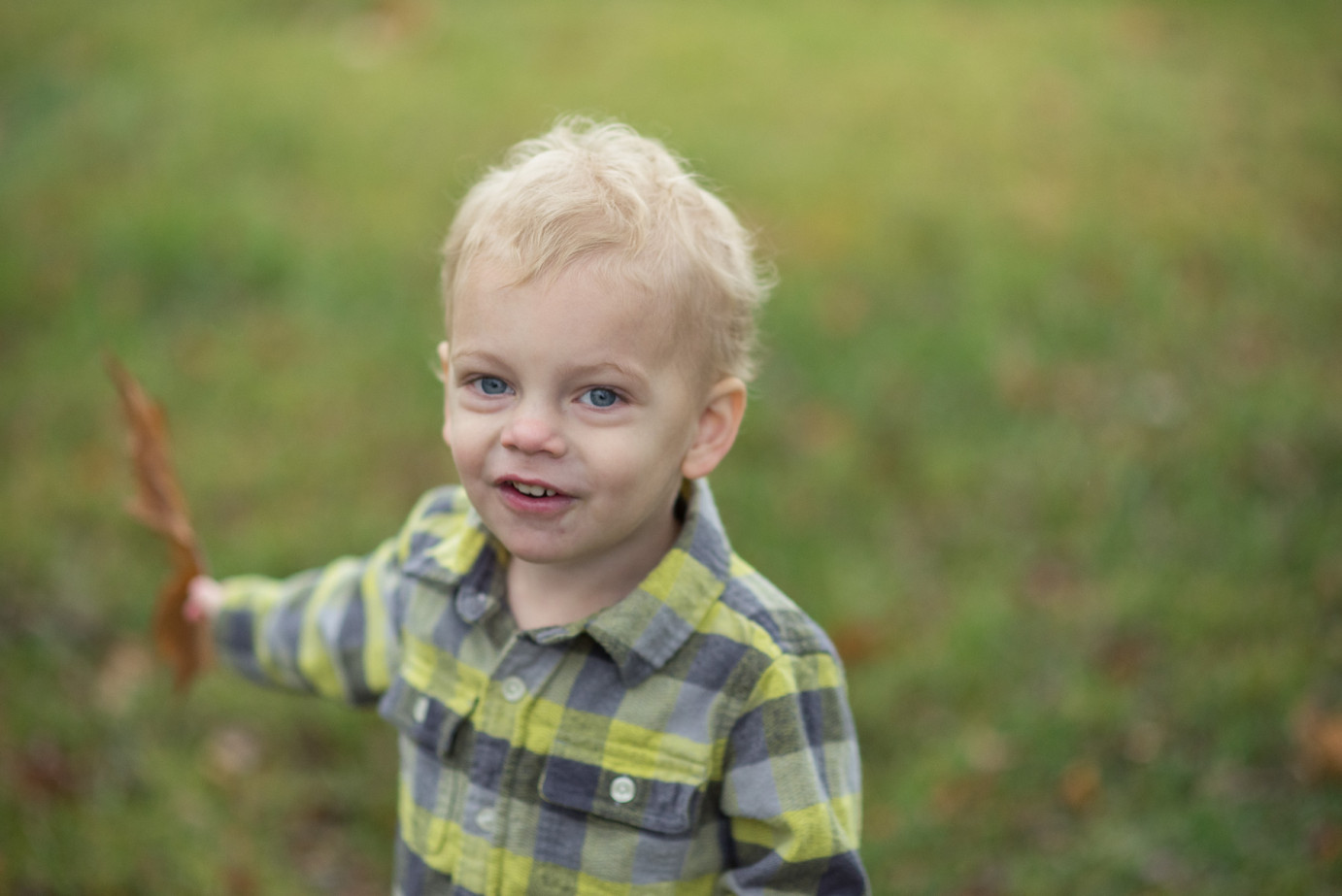 Tips for family photo sessions boy playing with huge leaf