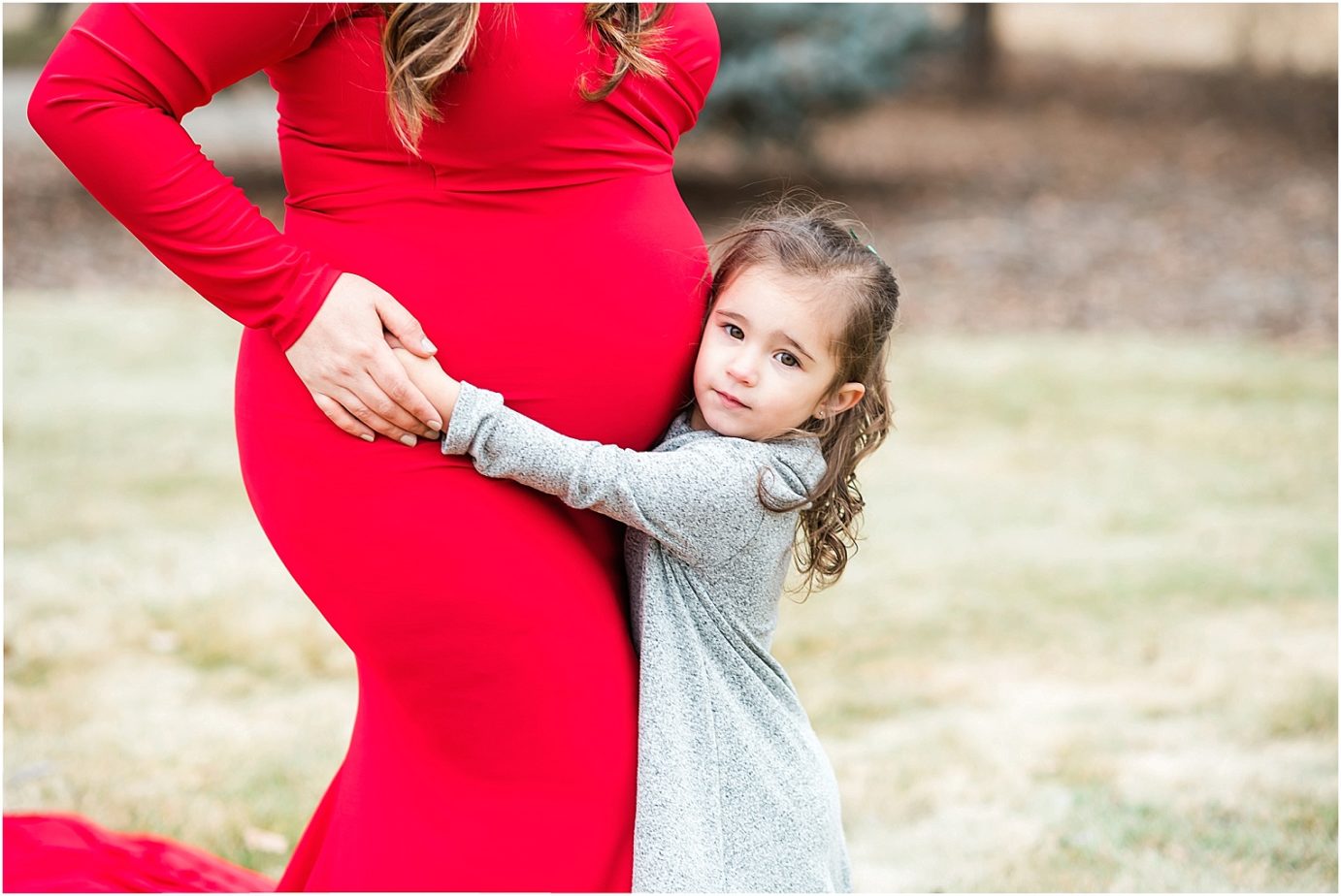 Maries maternity session prenant woman in long red dress with first child