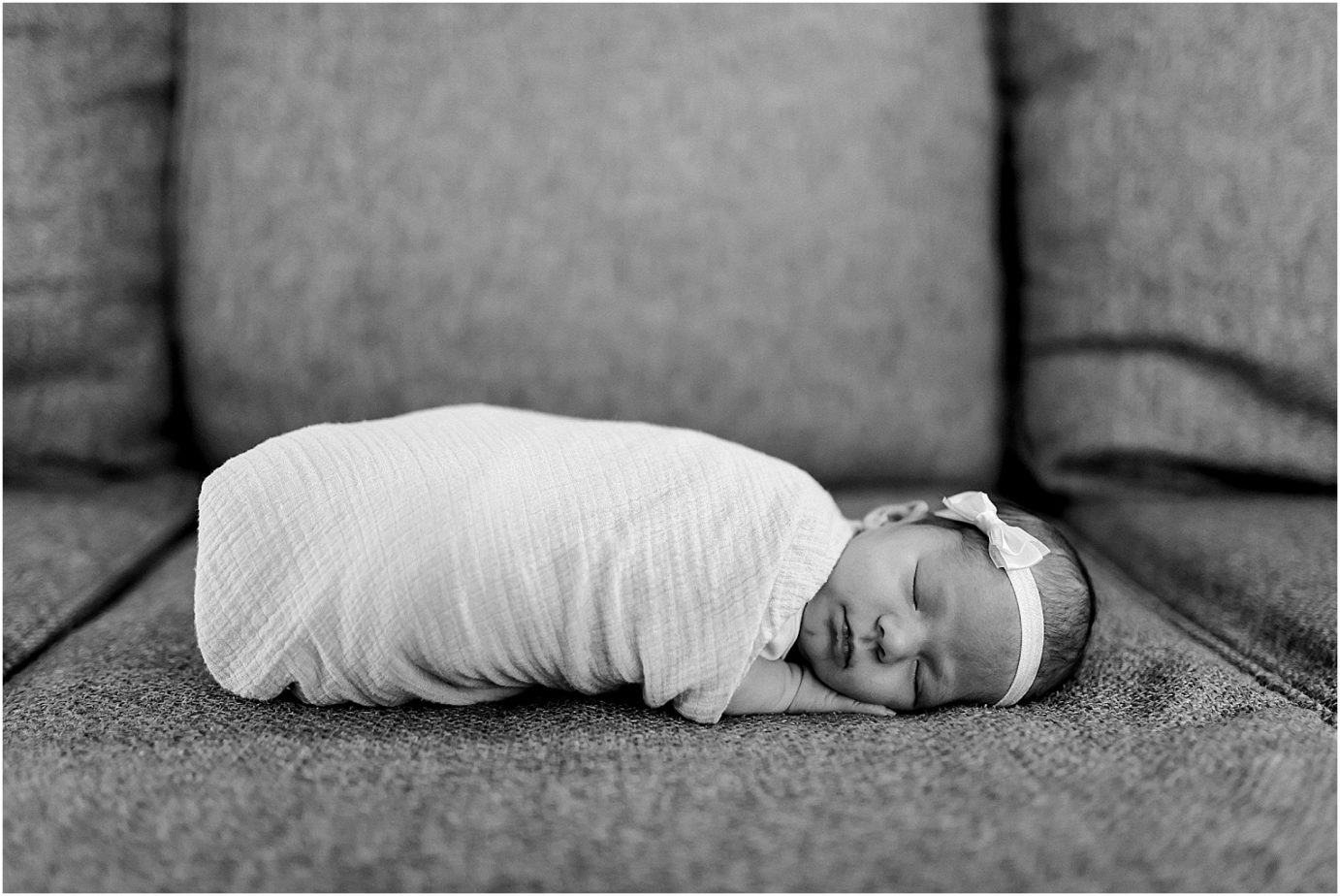 Newborn baby swaddled with bow