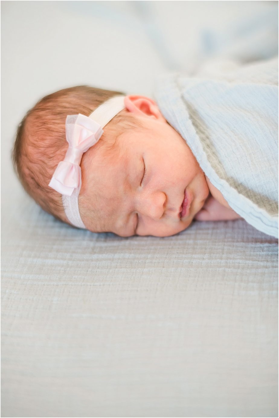 Newborn baby swaddled with bow