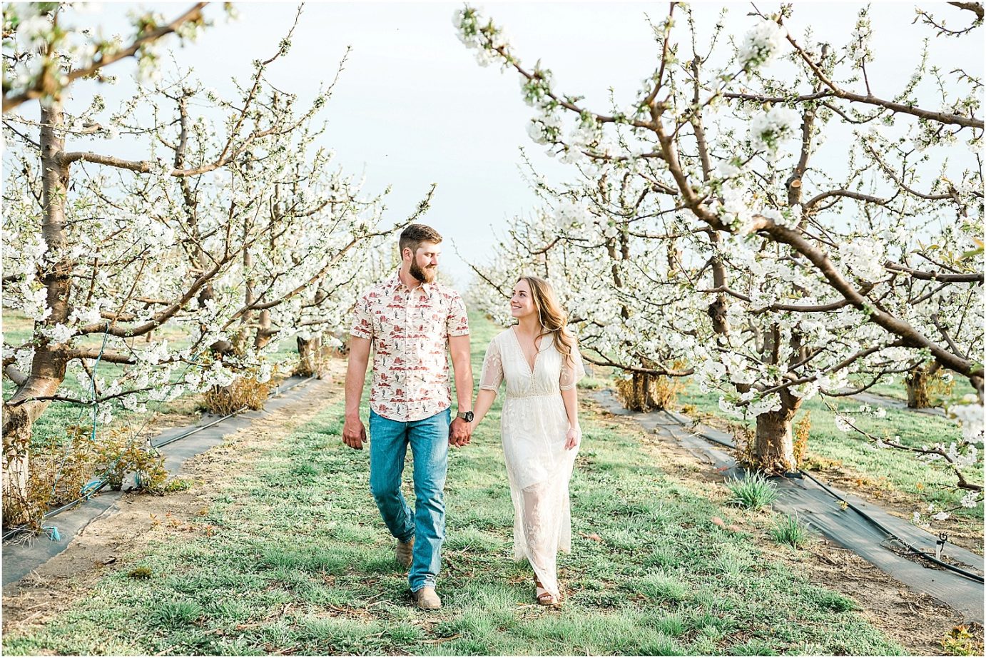 eastern washington engagement session PNW photographer Travis and arianna kissing around cherry blossoms