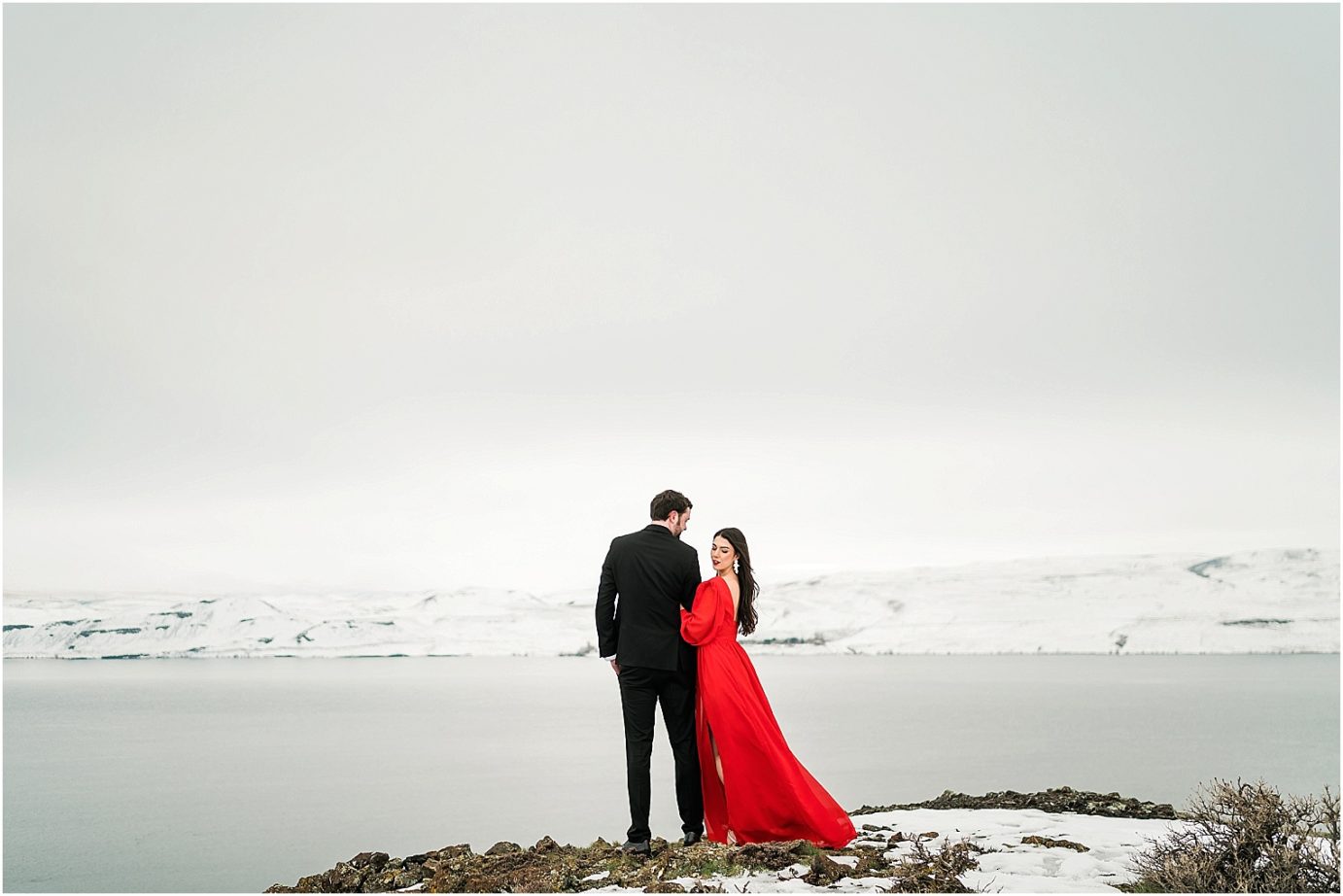 Winter engagement session Yakima Photographer Joel and Jaclyn bride in red dress in the snow on a cliff