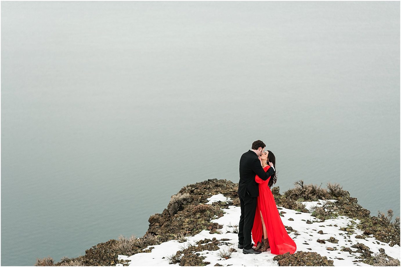 Winter engagement session Yakima Photographer Joel and Jaclyn bride in red dress in the snow on a cliff