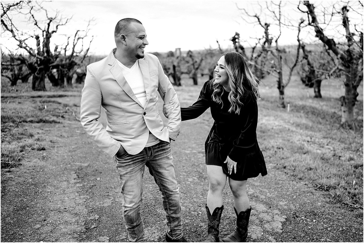 eastern washington engagement session juan and yenni laughing in an orchard