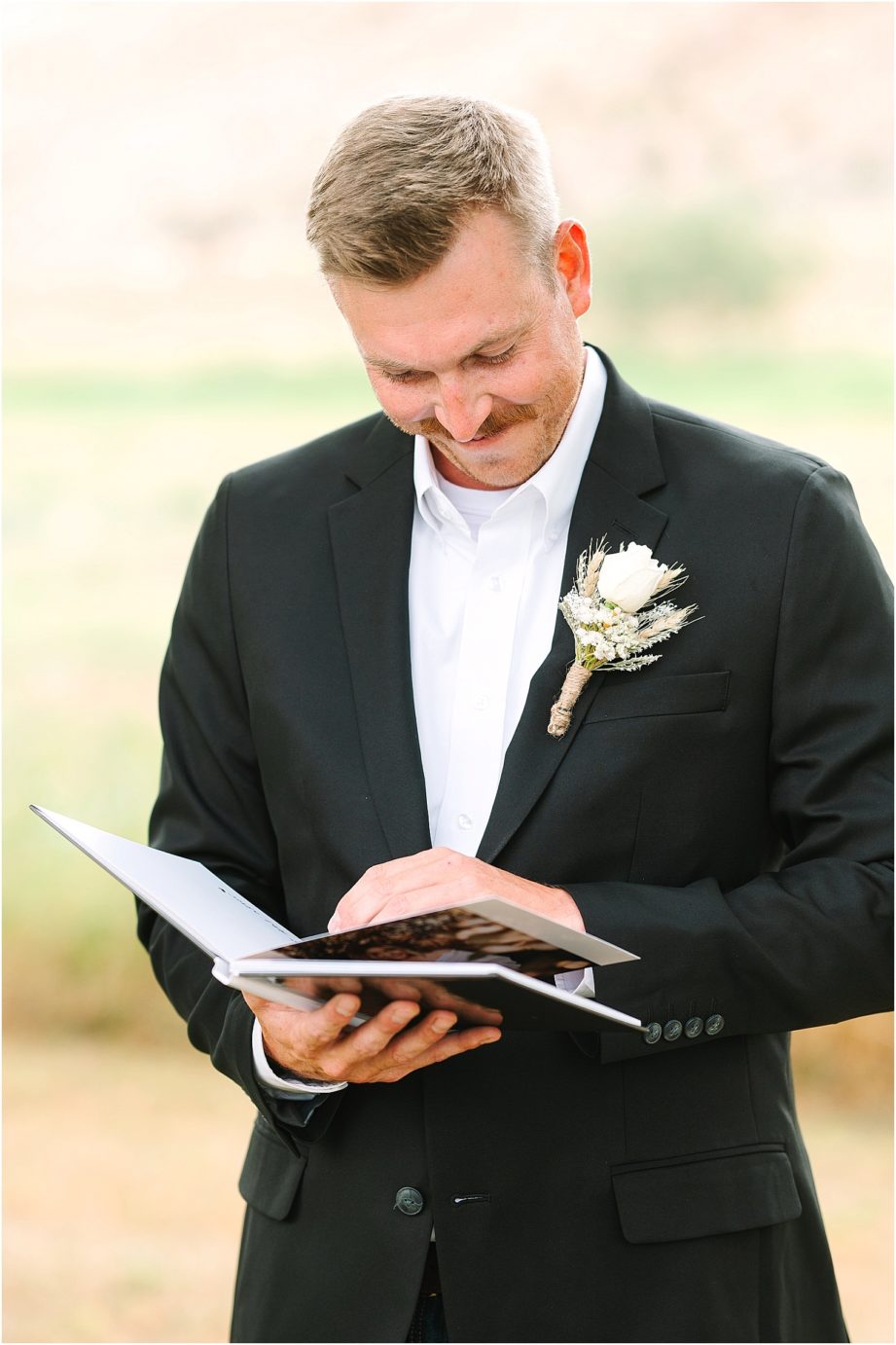 Party Barn at HJ Ranch Wedding groom looking at boudoir album from bride