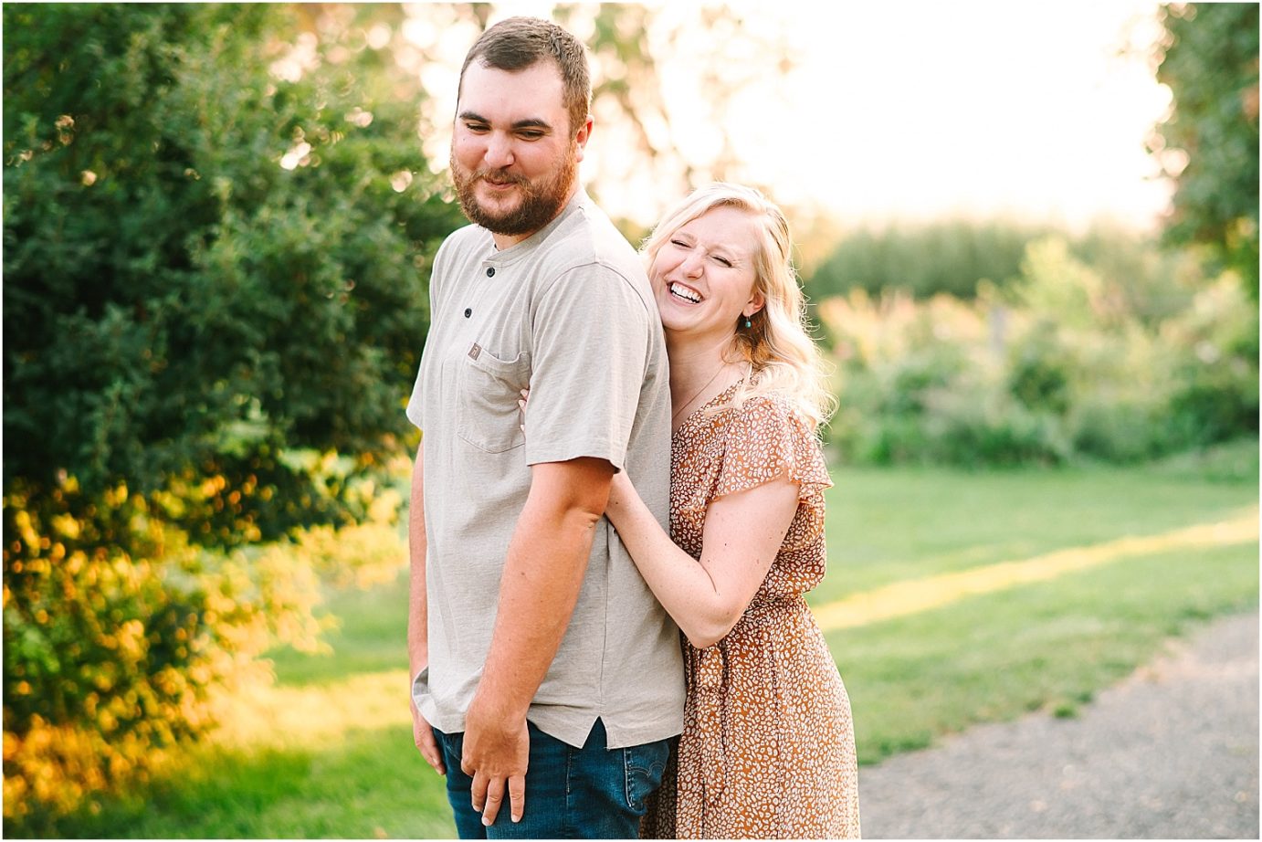 couple tickling each other during their garden engagement session