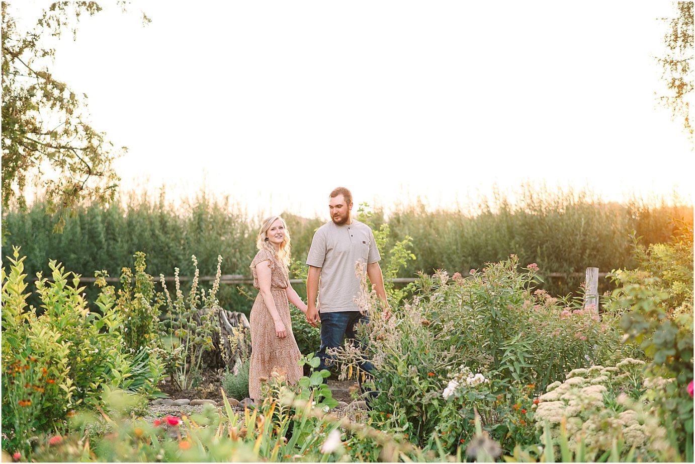 garden engagement session couple standing in the flowers
