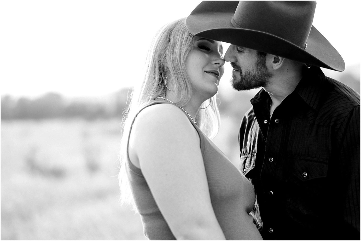 Engagement session in the desert Central WA Andrew and Shelby snuggling under a cowboy hat