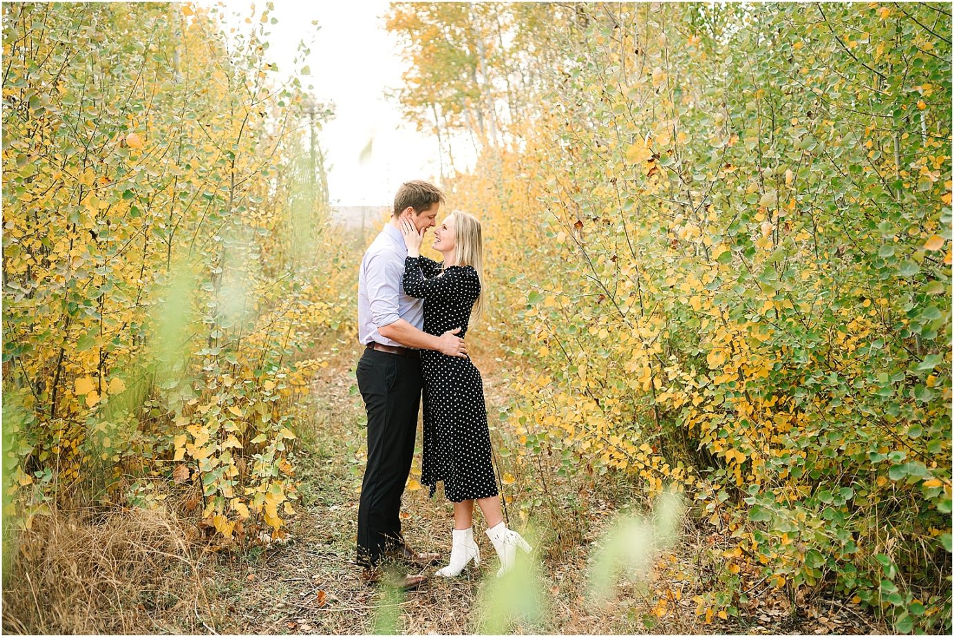 Joyful fall engagement session Cental WA Brad and Jasmine holding each other in a grove of trees