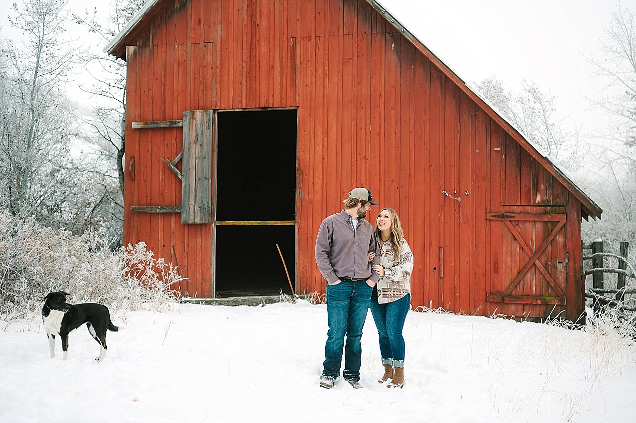 engagement session couple in front of a big red barn