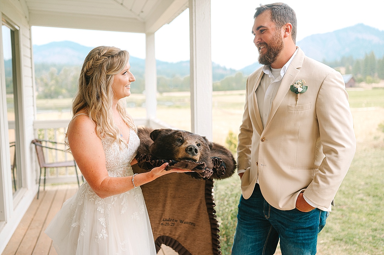 The Cattle Barn Wedding Ellensburg WA Andrew and Dani bride giving groom bear rug