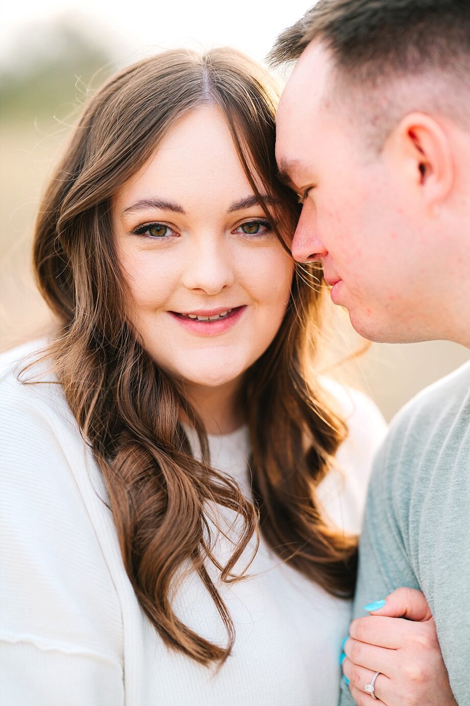 Riverside engagement session couple snuggling in the weeds