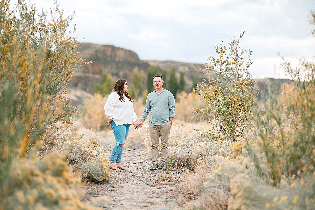 Riverside engagement session couple standing on a trail